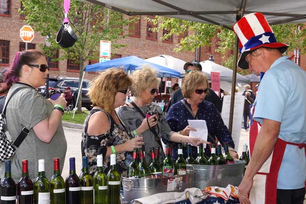women looking at wine bottles